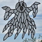 A ghost-shaped 3D printed window ornament with a black metal hanger at the top, shown hanging against a cloudy blue sky background.