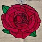 A 3D printed rose ornament with a red rose design, green leaves, and a clear hanging loop at the top, shown against a neutral background.