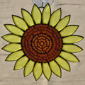 A 3D printed sunflower ornament with a textured brown center and bright yellow-green petals outlined in black, suspended by a clear hook at the top against a neutral background.